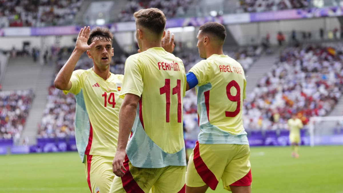El futbolista español Fermín López (c) celebra con sus compañeros Abel Ruiz (d) y Aimar Oroz (i) tras marcarle un gol a la República Dominicana. M. REINO