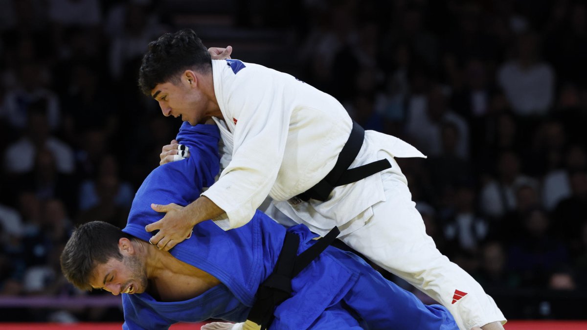 El judoca español Francisco Garrigos (azul) compite ante el georgiano Giorgi Sardalashvili durante el combate por la medalla de bronce de Judo -60 kg Masculino. CHEMA MOYA