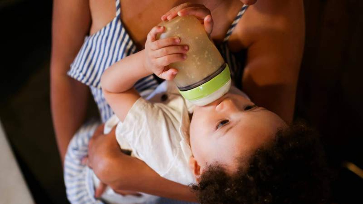 Niño bebiendo de un biberón en una foto de archivo. PEXELS