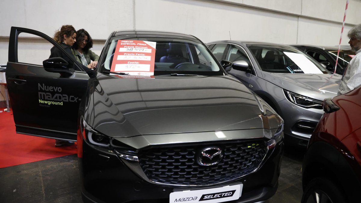 Un comercial atiende a clientes en una Feria del Vehículo Selección Ocasión. EFE/Luis Tejido