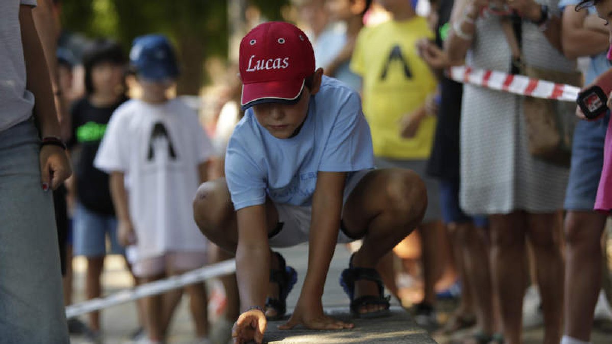 Uno de los niños afina su puntería con las chapas. FERNANDO OTERO