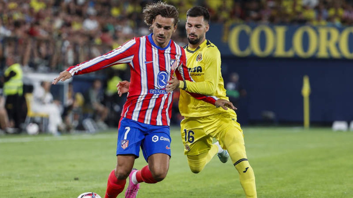 El jugador del Villarreal Álex Baena pelea por el balón con el delantero francés del Atlético de Madrid Antoine Griezmann. MANUEL BRUQUE