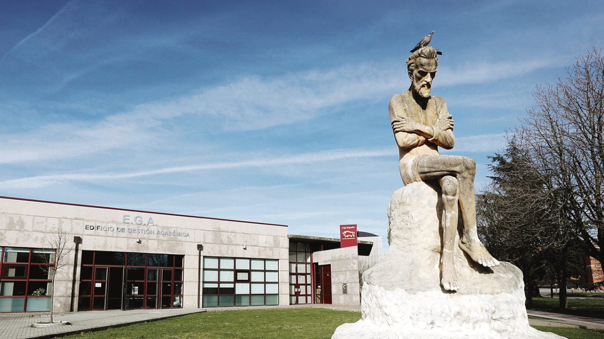 Estatua del pensador en el Campus, con el Edificio de Gestión Académica al fondo.