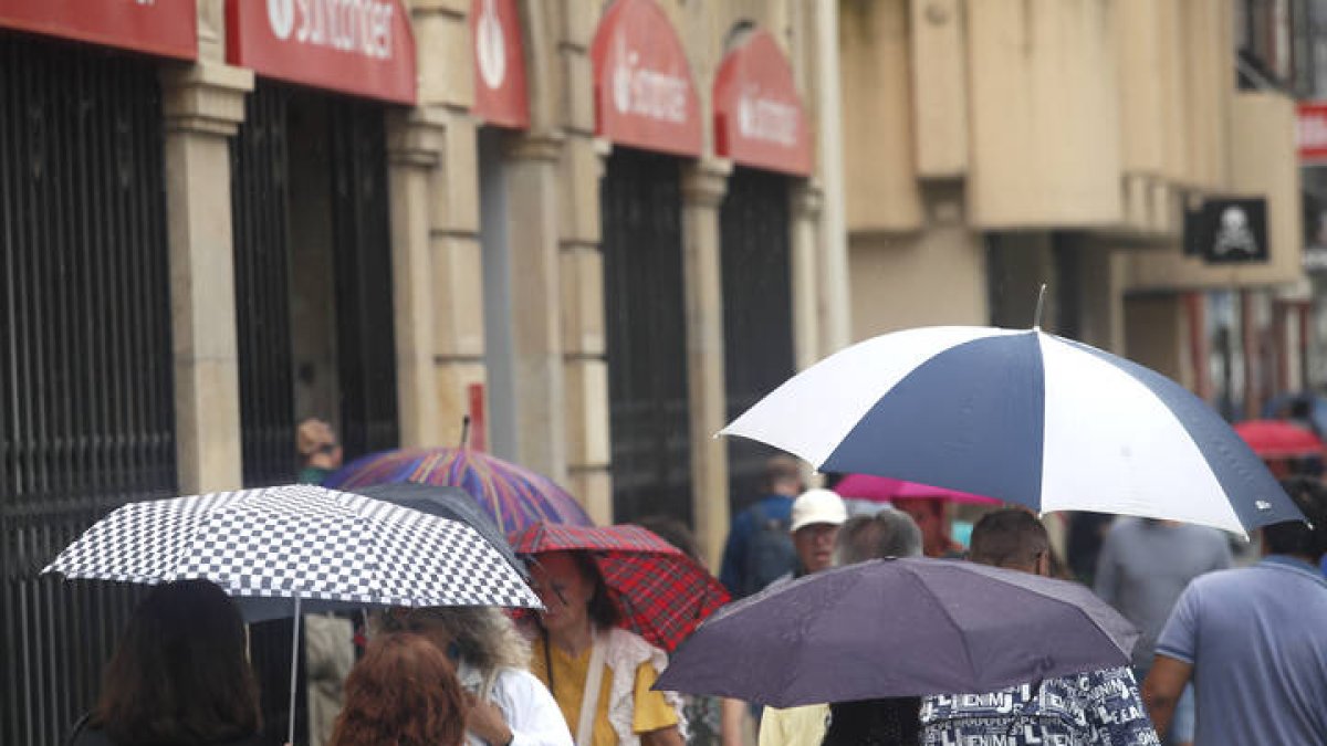 Varias personas se protegen de la lluvia en Ordoño.