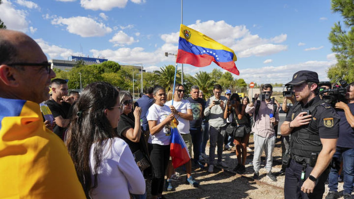 Simpatizantes del excandidato opositor a la Presidencia de Venezuela, Edmundo González Urrutia, conversan con un miembro de la Policía Nacional en la puerta de la base aérea de Torrejón de Ardoz (Madrid)