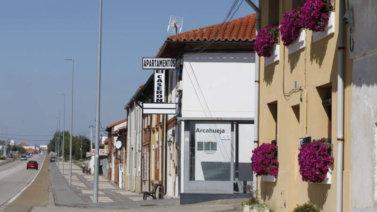 La iglesia de Valdelafuente y vista del pueblo de Arcahueja. Abajo, unos peregrinos surcan este tramo del Camino.