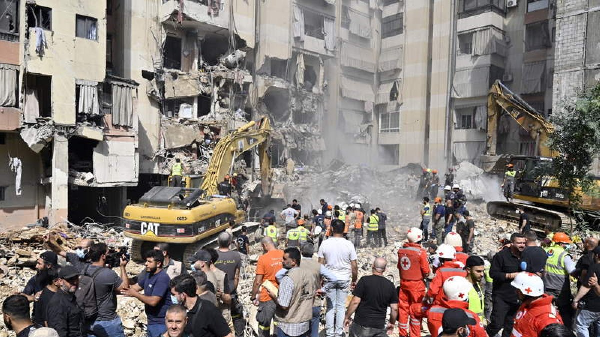 Trabajadores de emergencia usan excavadoras en el lugar que fue blanco de un ataque israelí. WAEL HAMZEH