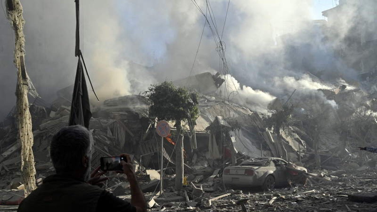 Un hombre hace una fotografía tras el bombardeo de un barrio de Beirut. STR