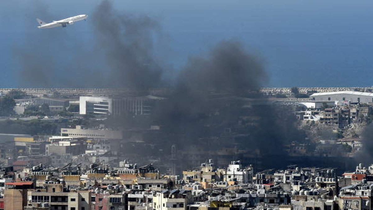 Un avión vuela en medio del humo tras un ataque aéreo israelí en el bastión de Hizbolá en Dahieh, un suburbio al sur de Beirut. WAEL HAMZEH