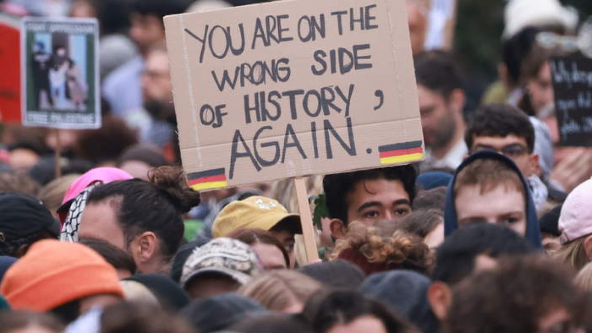 Un manifestante lleva en Berlín una pancarta que dice ‘Estás en el lado equivocado de la historia otra vez’. CLEMENS BILAN