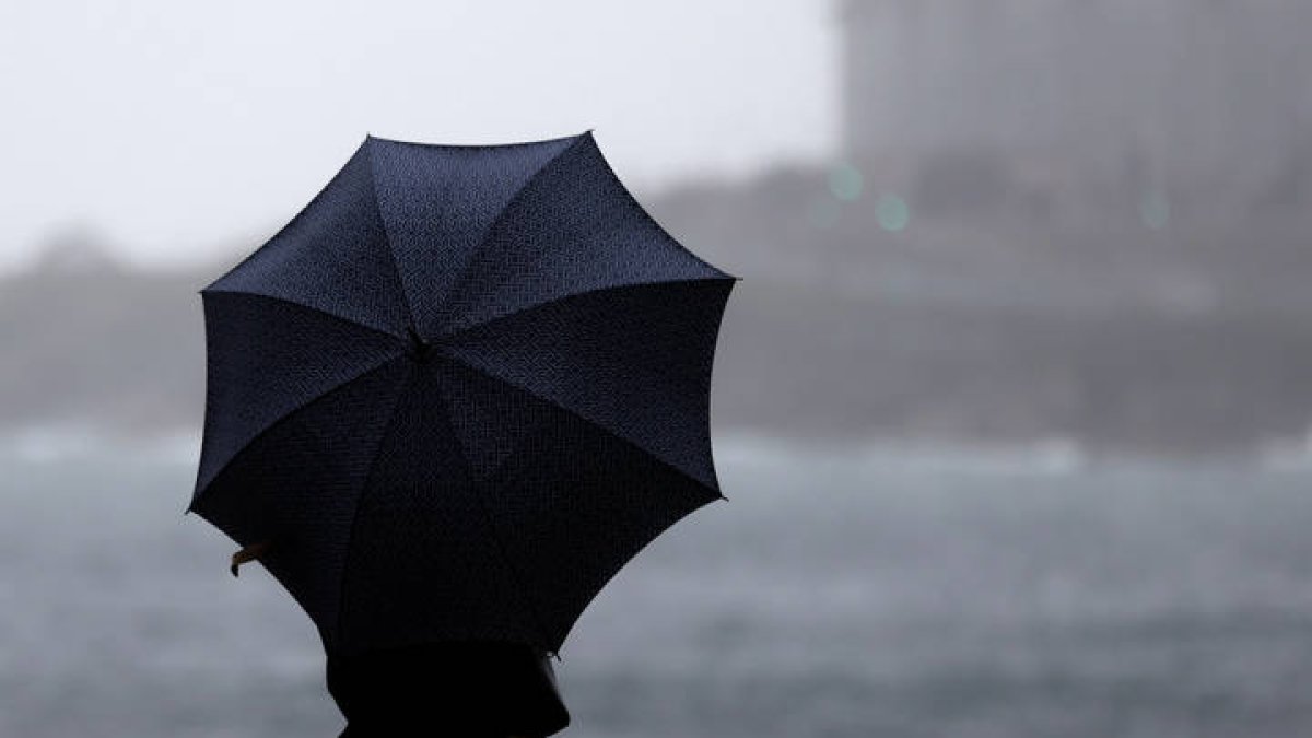 Una mujer lucha contra el viento.