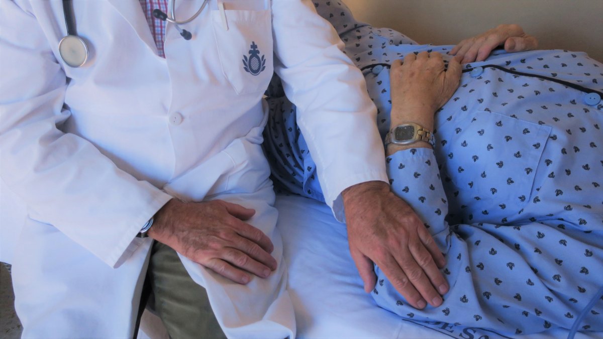 Un sanitario con un paciente en un hospital de San Juan de Dios.
