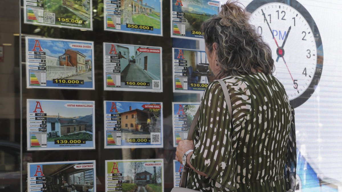 Imagen de archivo de una mujer delante del escaparate de una agencia inmobiliaria. EFE/J.L.Cereijido