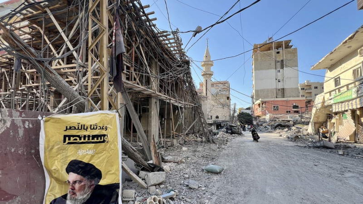 Una foto del líder asesinado de Hezbolá, Nasrallah, en un edificio dañado por un ataque en Tiro.  STR