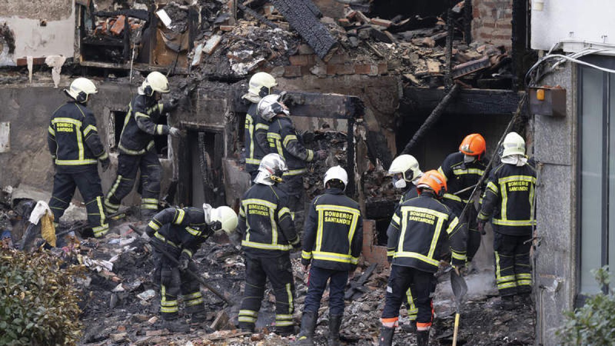 Imagen de los bomberos en el desescombro. PEDRO PUENTE HOYOS