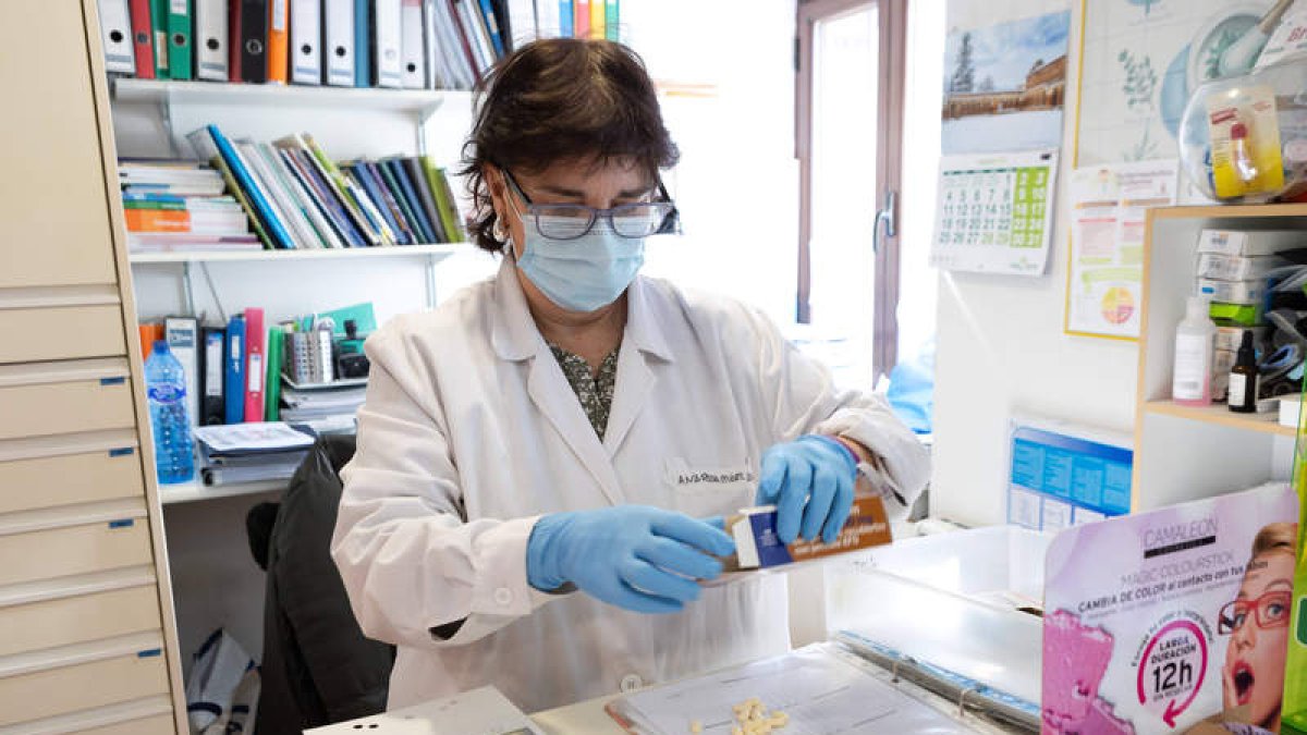 Imagen de una farmacéutica preparando una medicación para un enfermo.  CONCHA ORTEGA