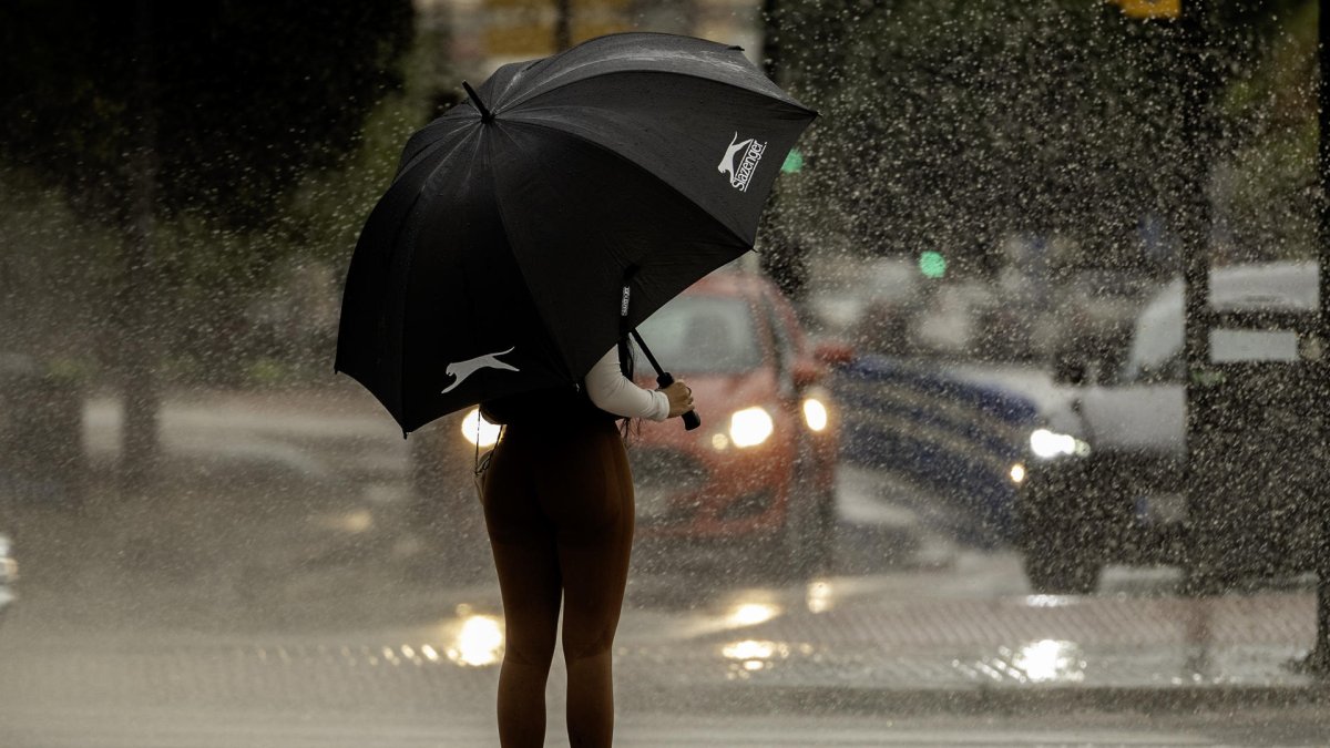 Una mujer se resguarda de la lluvia bajo un paraguas este martes en Málaga.EFE/Jorge Zapata.