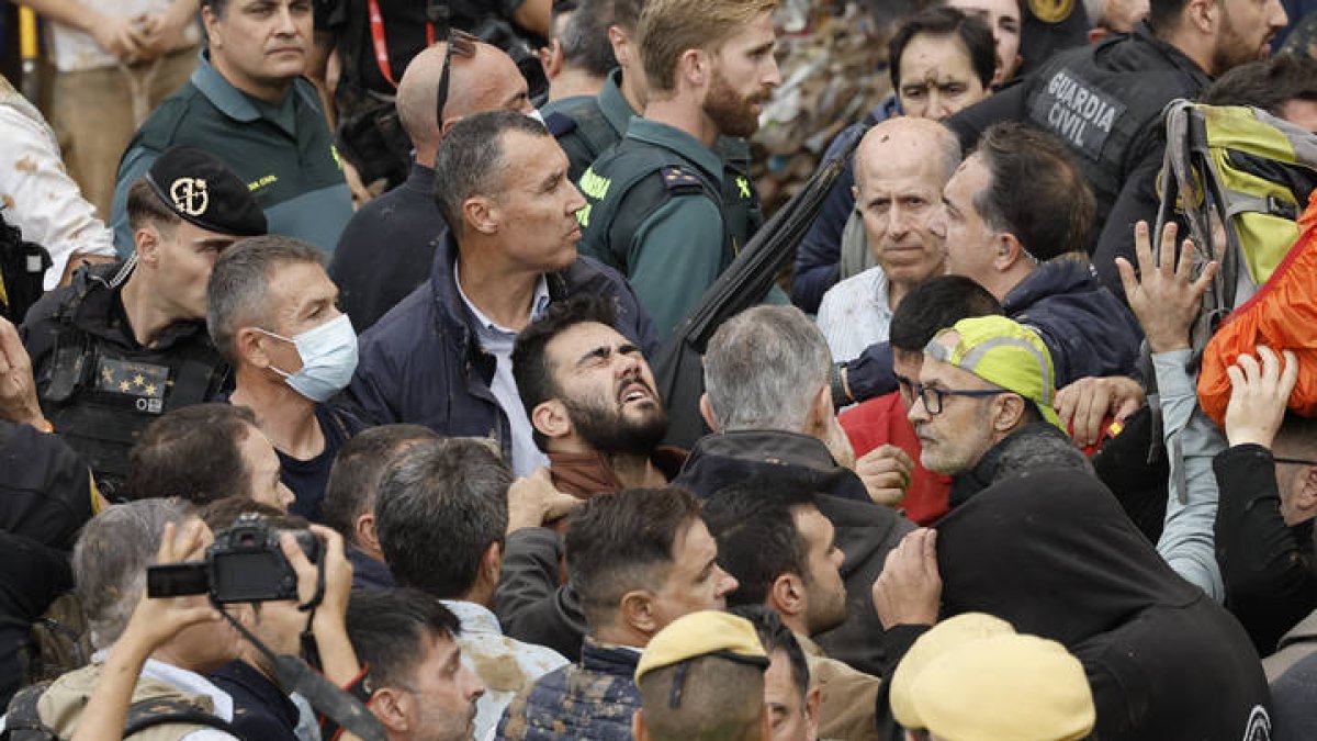 El rey Felipe (c) habla vecinos afectados por la riada, durante su visita a Valencia este domingo. Gritos de 'fuera', así como lanzamiento de barro, están recibiendo a la comitiva de los reyes de España, el presidente del Gobierno, Pedro Sánchez, y el president de la Generalitat, Carlos Mazón, a su llegada al centro de Paiporta.