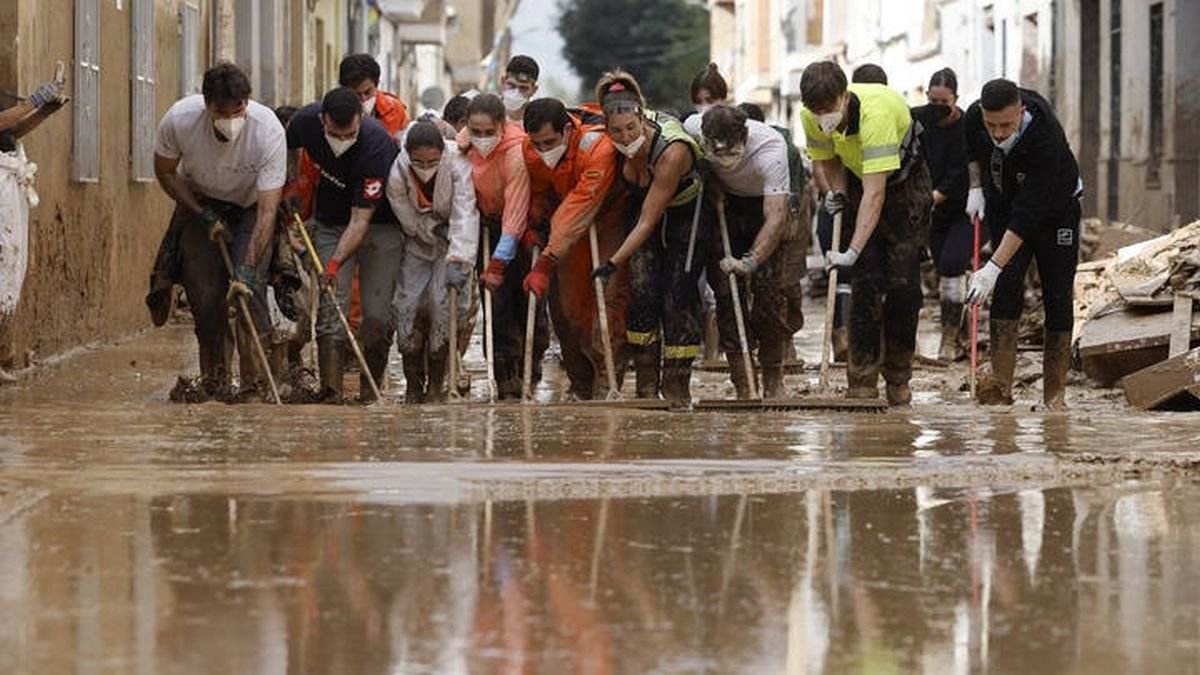 Voluntarios limpian una calle en Masanasa. EFE Kai Försterling