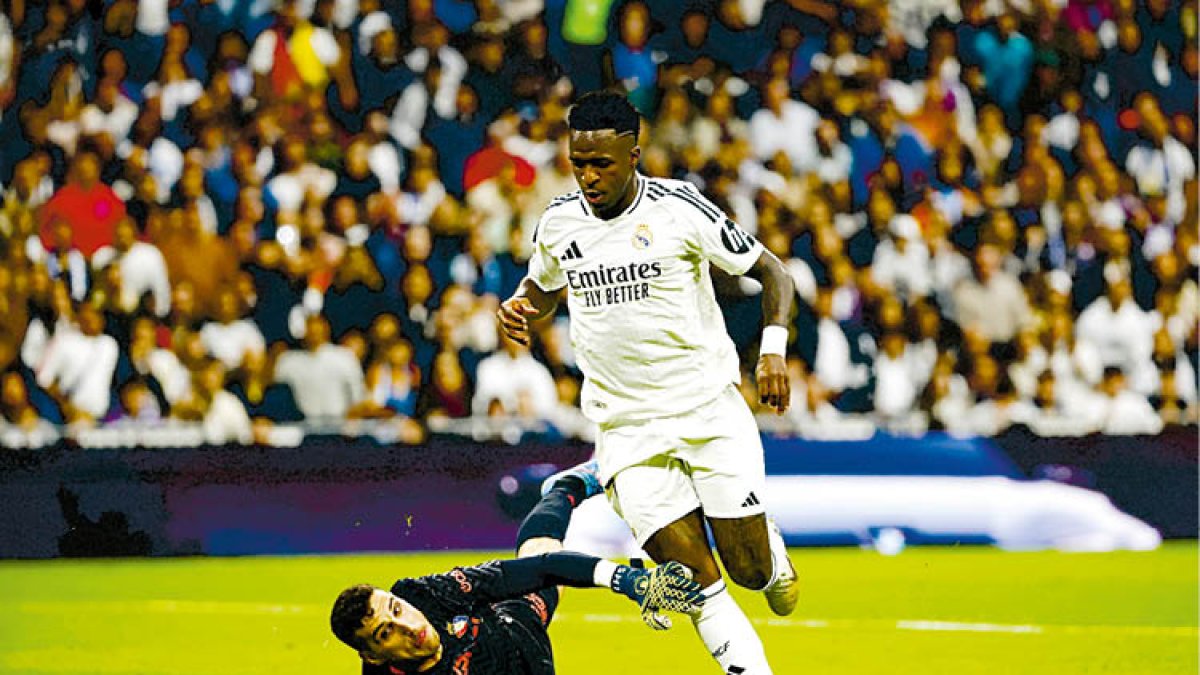 Vinicius, autor de tres goles, regatea al portero rival.