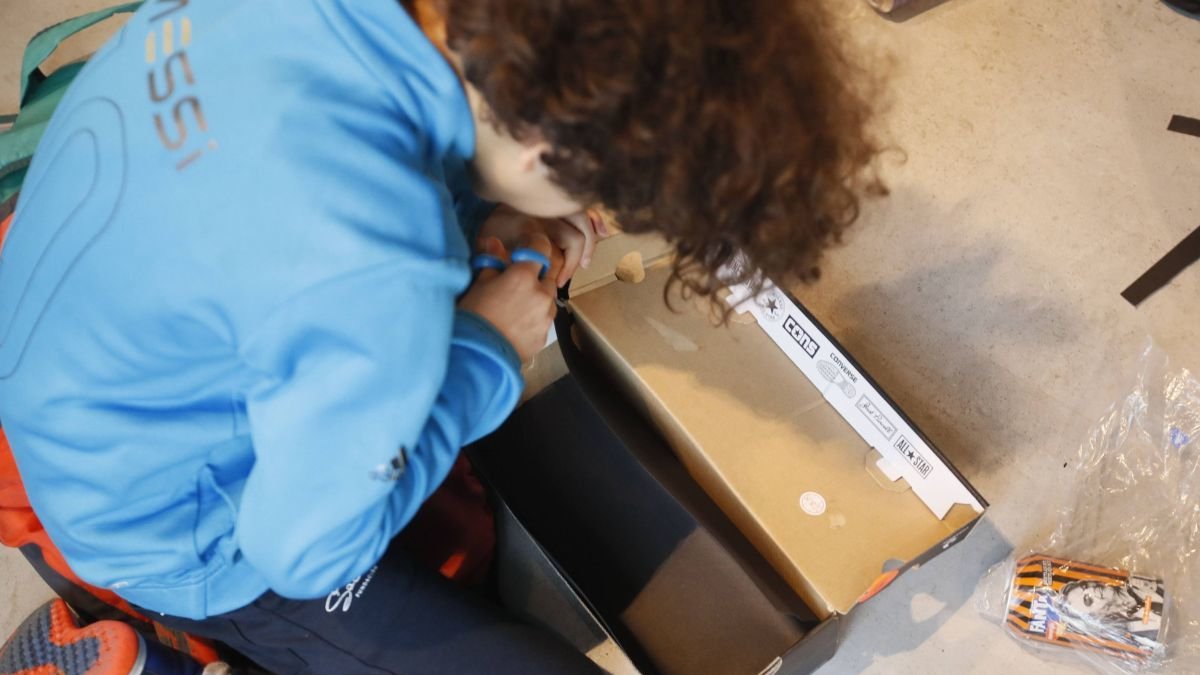 Varios niños y niñas utilizan material reciclado para construir una cámara fotográfica, ayer en el Palacín. ÁNGELOPEZ (Con una caja de zapatos se pueden hacer fotografías. ÁNGELOPEZ)