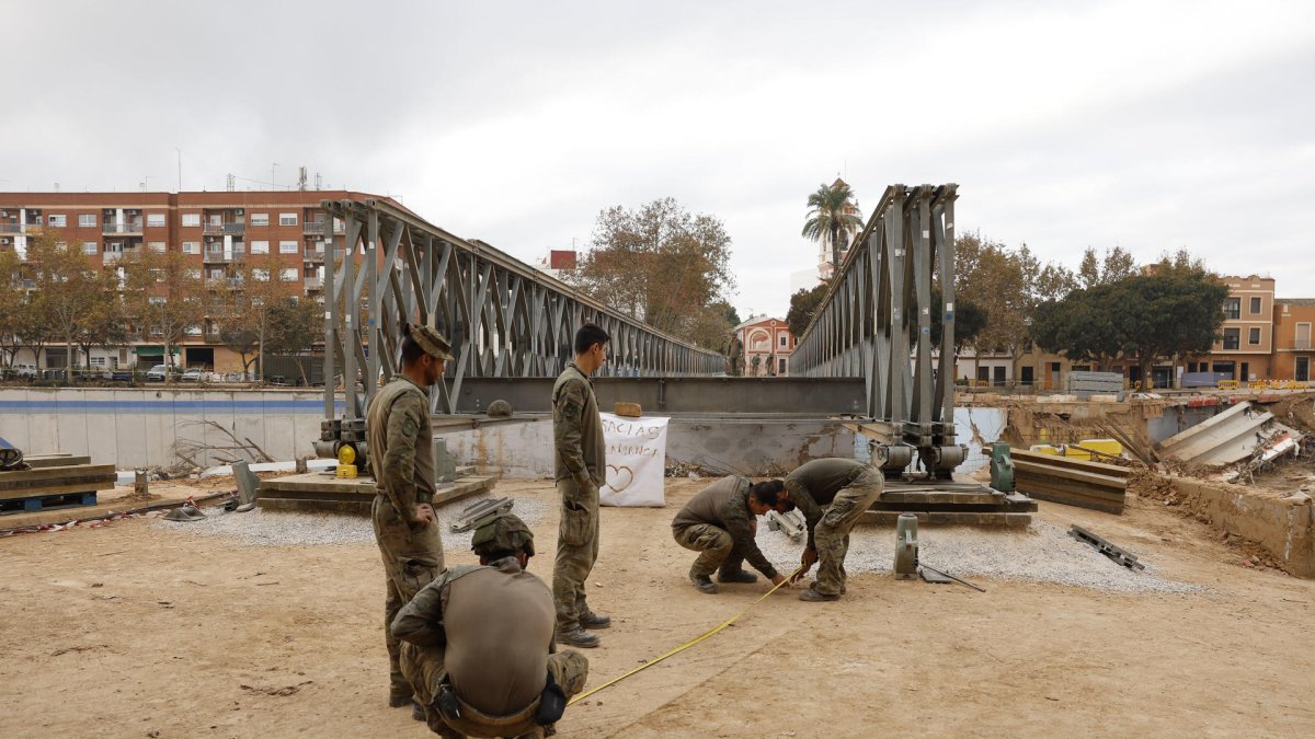 Zapadores del ejército de Tierra avanzan en la construcción de una pasarela militar en Picanya (Valencia), este domingo. EFE/Villar López