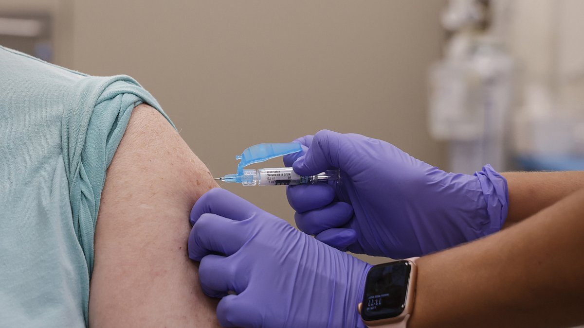 Archivo - Una mujer se vacuna durante el inicio de la campaña de vacunación frente a la gripe y la Covid-19