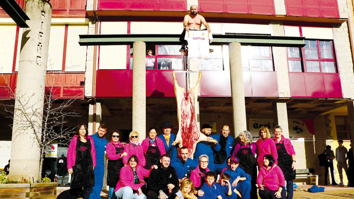 Las mujeres de la asociación y los mozos matarifes junto al cerdo.