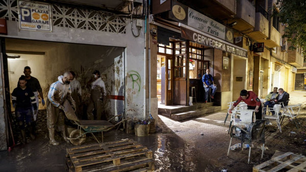 Un grupo de voluntarios continuaba a última hora de esta tarde de viernes sacando lodo de un garaje junto al barranco del Poyo en Paiporta.