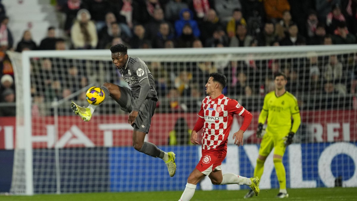 El centrocampista del Real Madrid Tchouaméni (i) disputa un balón ante el delantero del Girona Bojan Miovski. Alejandro García