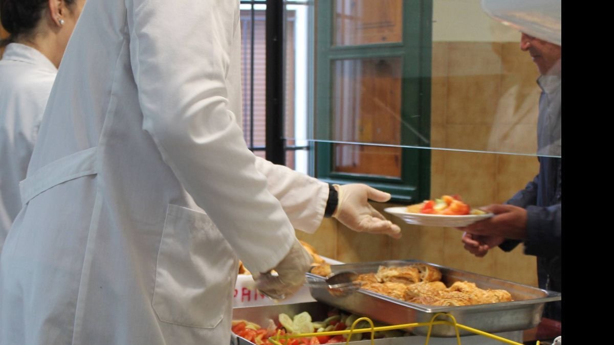 Voluntarios de Asleca reparten comida en el comedor social. dl