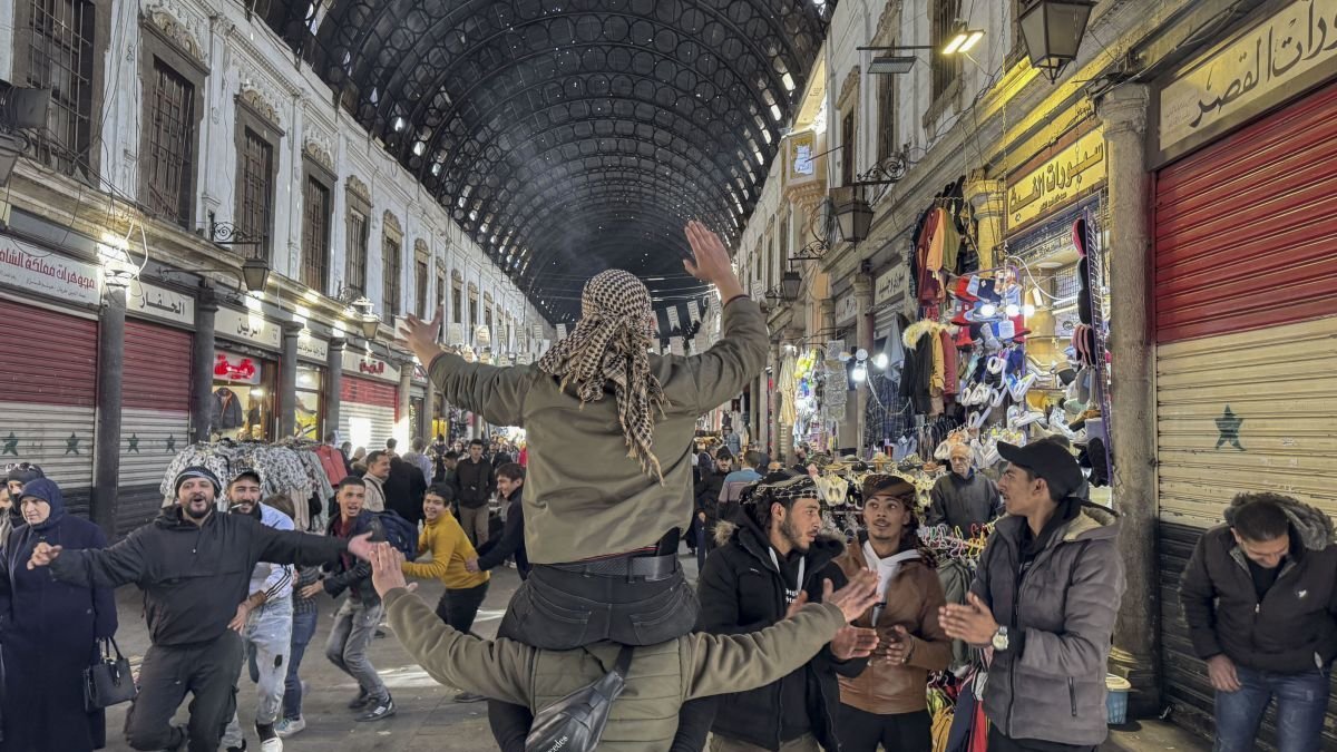 Personas bailan y dan muestras de alegría en el zoco de Al Hamidiya. Yahya Nemahiei
