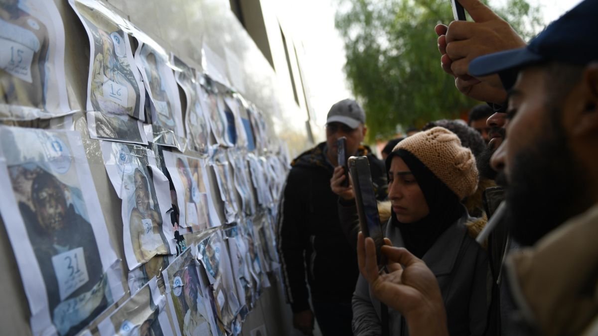 Los sirios buscan a sus familiares entre las fotos de los muertos hallados en las cárceles. h. bella