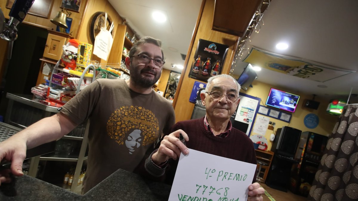 José Ángel Álvarez y su padre Orfesino, con el cartel con el número premiado hecho a mano por ellos mismos.