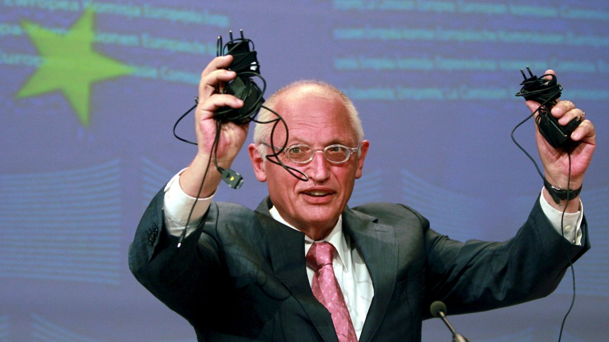 El vicepresidente de la Comisión Europea y comisario europeo de Empresa e Industria, Günter Verheugen, muestra un cargador de teléfono móvil durante una rueda de prensa en Bruselas (Bélgica).