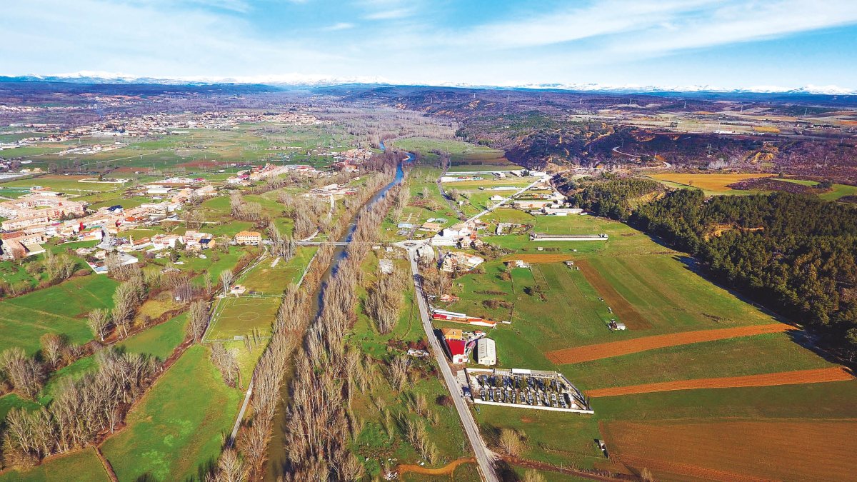 Vista del río Torío a su paso por Villaobispo, con la cordillera Cantábrica al fondo.