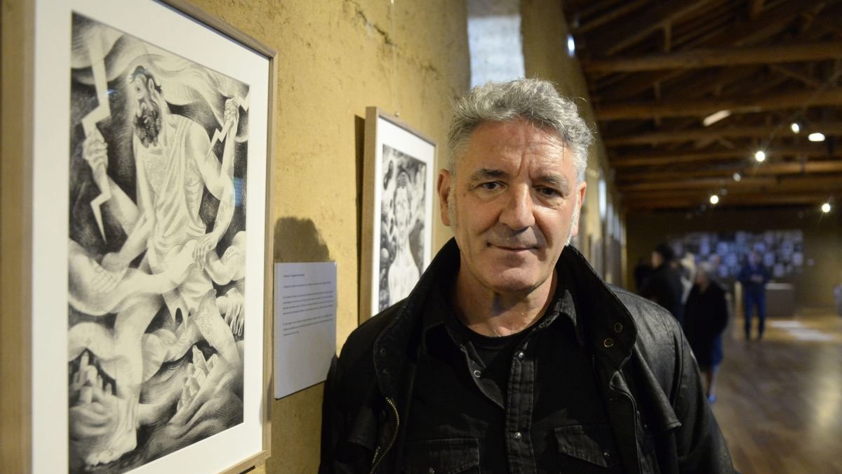 El ilustrador leonés Toño Benavides junto a uno de sus dibujos de personajes mitológicos. MARÍA FUENTES