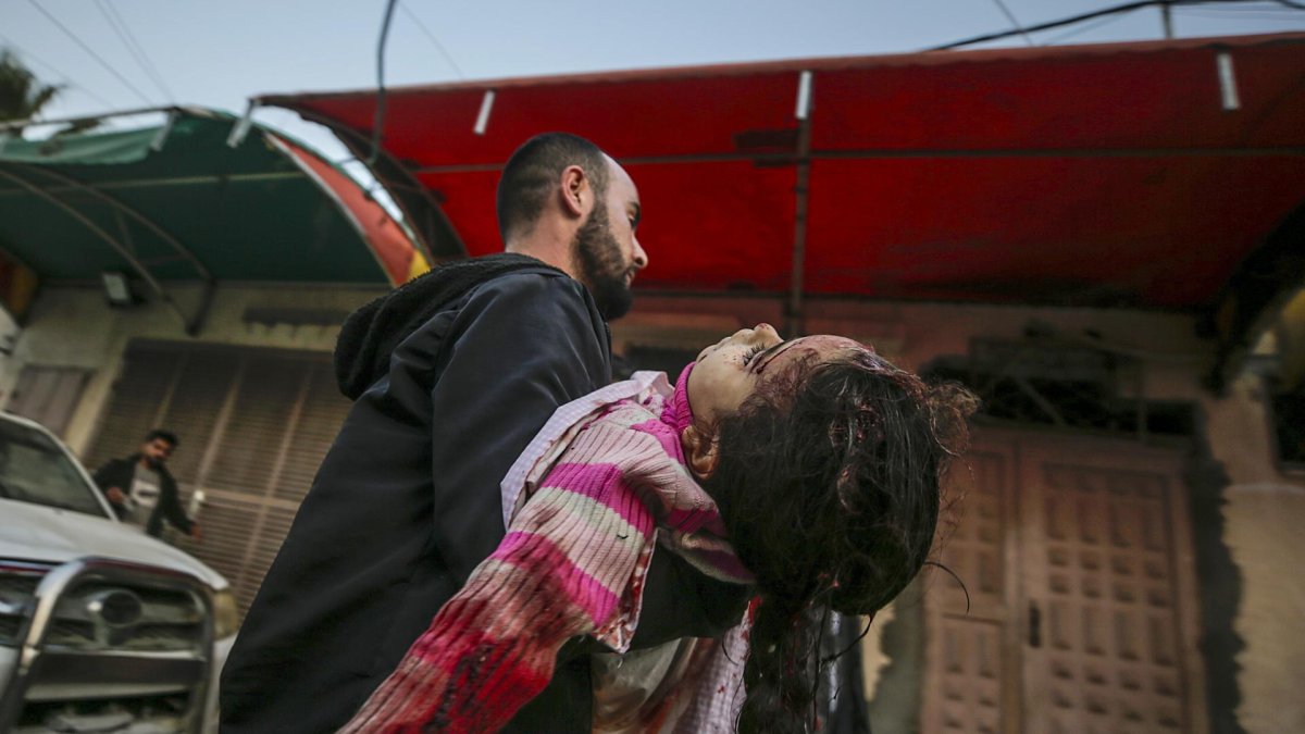 Un palestino traslada el cuerpo de un niña herida a un hospital de Deir Al Balah, en el centro de Gaza. EFE/EPA/MOHAMMED SABER