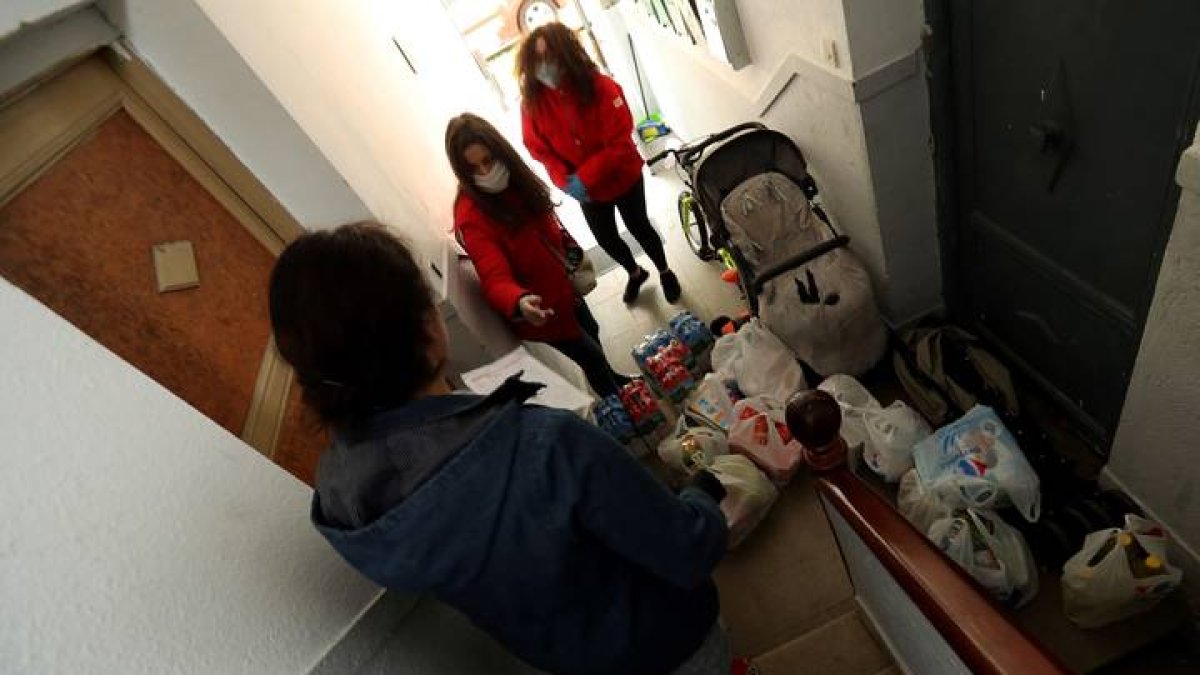 Voluntarias de la Cruz Roja reparten alimentos a domicilio a vecinos sin recursos, en una imagen de archivo