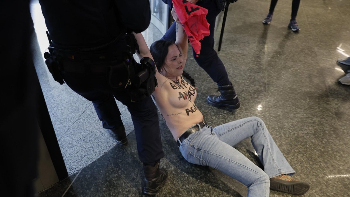 Una activista de FEMEN es retirada a la fuerza tras irrumpir en la primera cumbre de Patriotas, alianza de la extrema derecha europea, que se celebró en Madrid