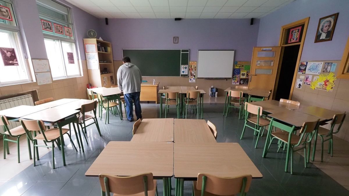 Un profesor prepara un aula antes de la llegada del alumnado.