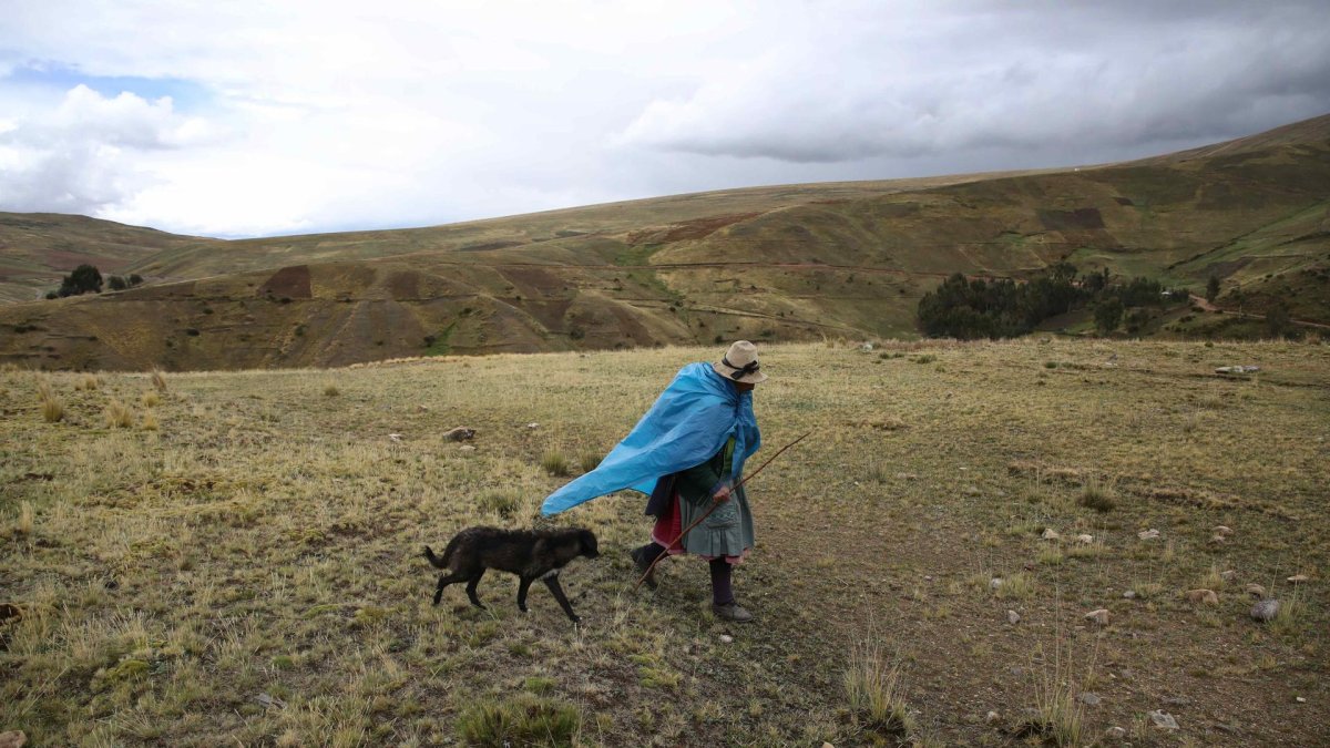 Fotografía de archivo de un campesino que camina bajo la lluvia en Perú.