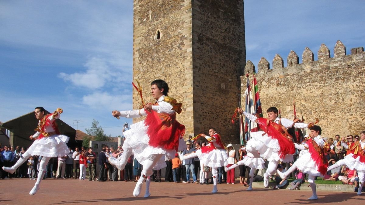 Varios danzantes de Laguna de Negrillos bailan en una exhibición ante el castillo.