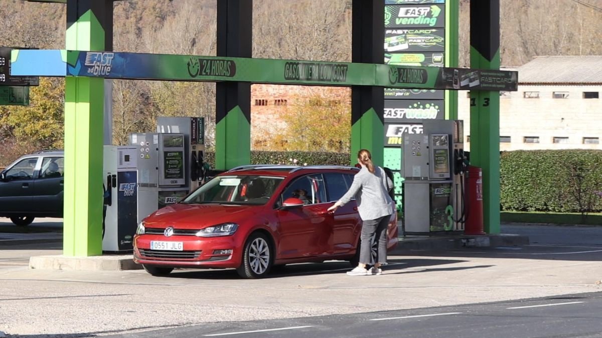 Una mujer reposta gasolina en una estación de servicio.