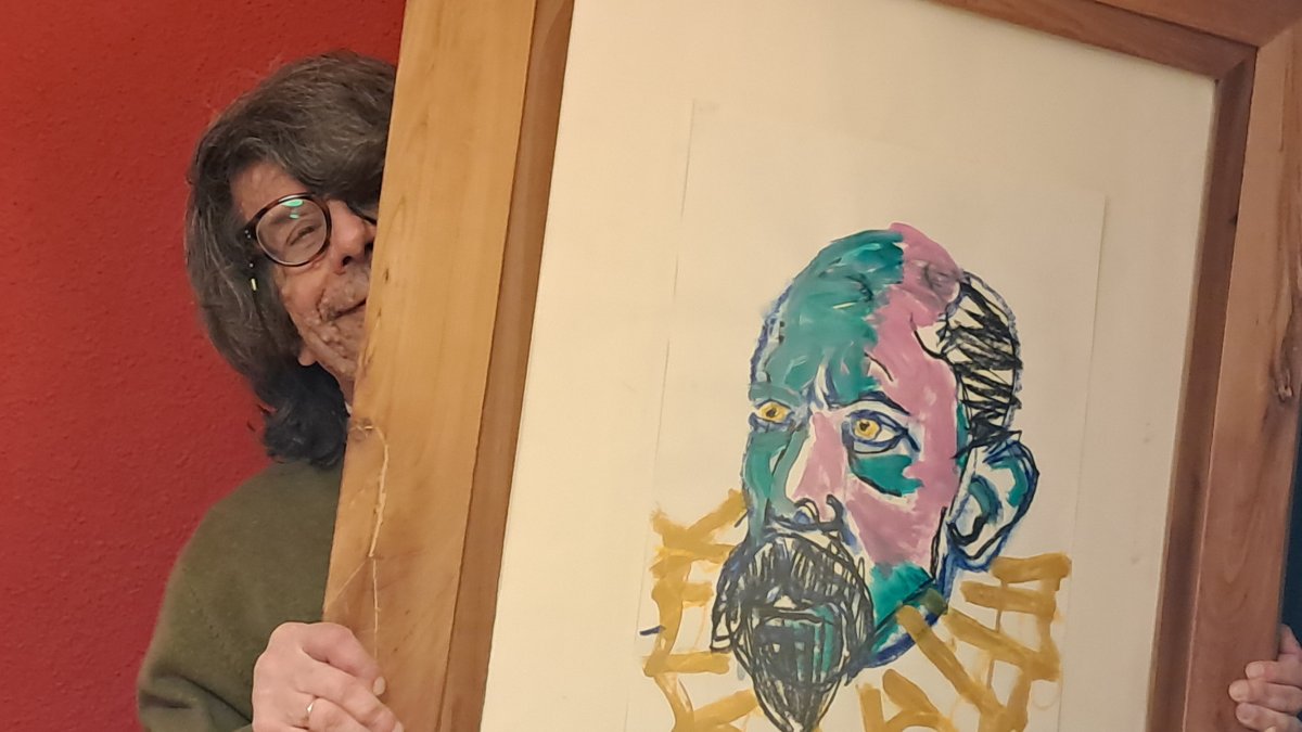 Eduardo Aguirre con una ilustración de Cervantes realizada por Nicolás M. Roa.