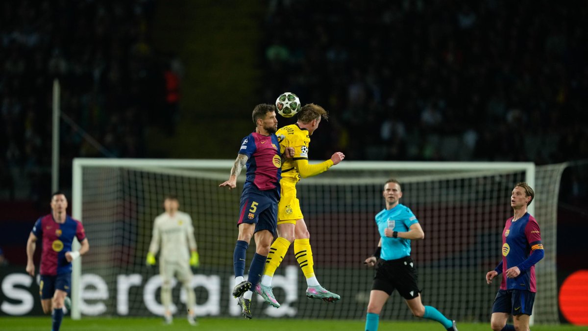 El defensa del FC Barcelona, Iñigo Martínez (i), disputa el balón ante el centrocampista del Borussia, Julian Brandt, durante el encuentro correspondiente a la ida de los cuartos de final de la Liga de Campeones que disputan hoy miércoles FC Barcelona y Borussia Dortmund en el Estadio Olímpico de Montjuic, en Barcelona. EFE / Alejandro Garcia.