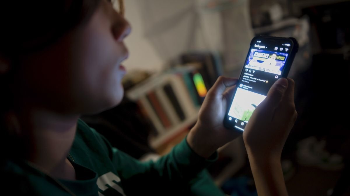 Un joven interacciona a través de un teléfono móvil.