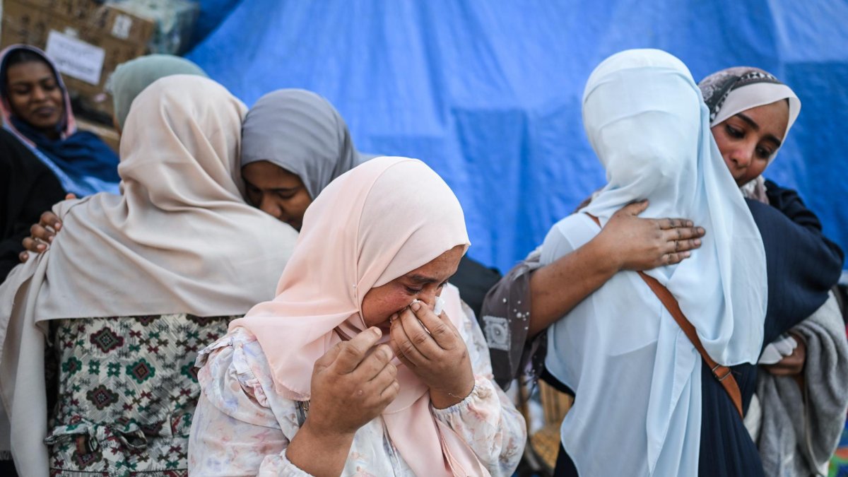 Mujeres refugiadas sudanesas se abrazan y lloran en un punto de reunión para autobuses organizados para su regreso voluntario desde Egipto a Sudán, en El Cairo. EFE/EPA/MOHAMED HOSSAM