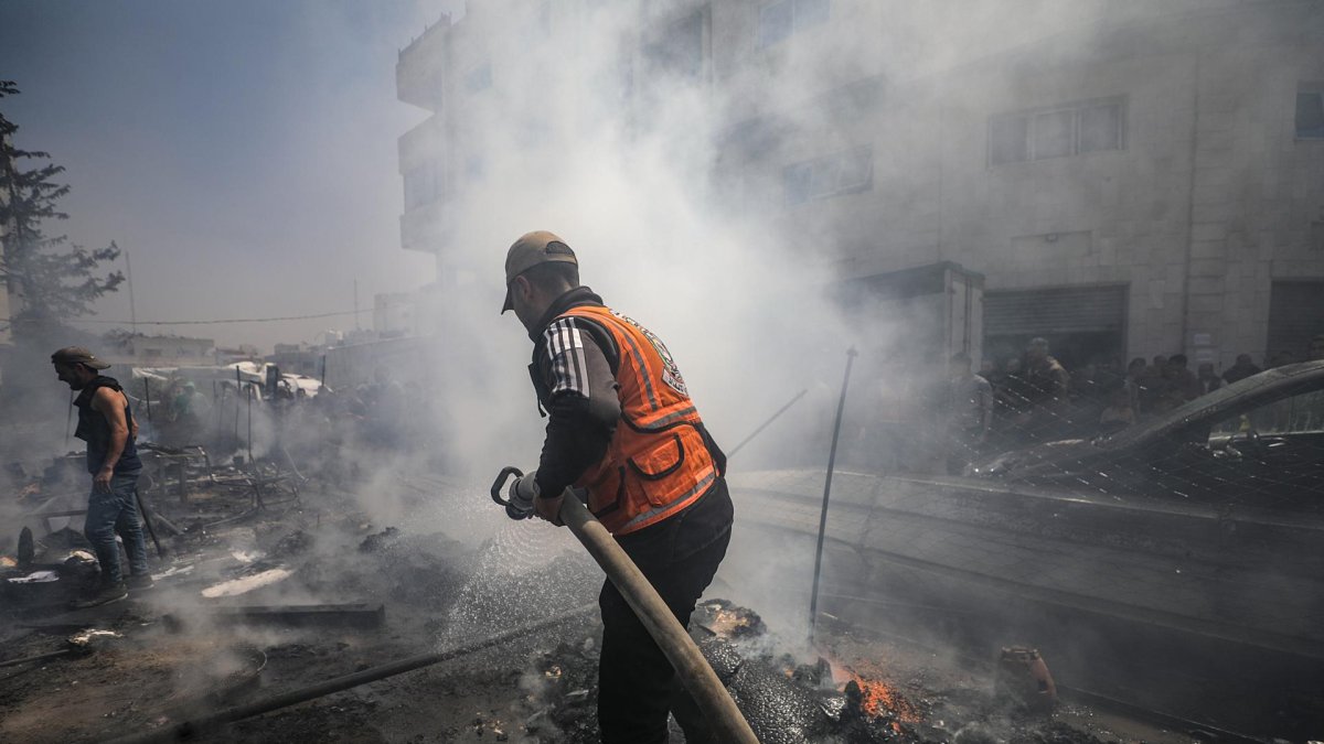 Un trabajador de la defensa civil palestina apaga el fuego de una tienda de campaña tras un ataque israelí el 21 de abril de 2025. EFE/EPA/MOHAMMED SABER