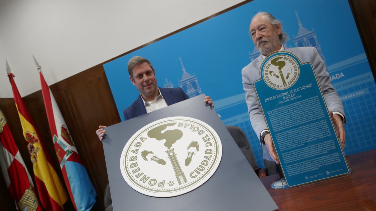 El concejal de Turismo de Ponferrada y el presidente de la Delegación del Colegio de Arquitectos, con el logotipo del proyecto.
